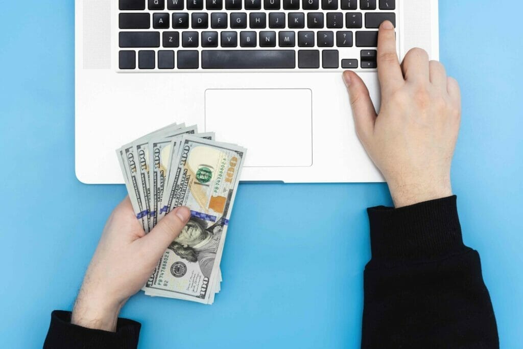 laptop and money in male hands top view 2023 01 06 23 25 28 utc