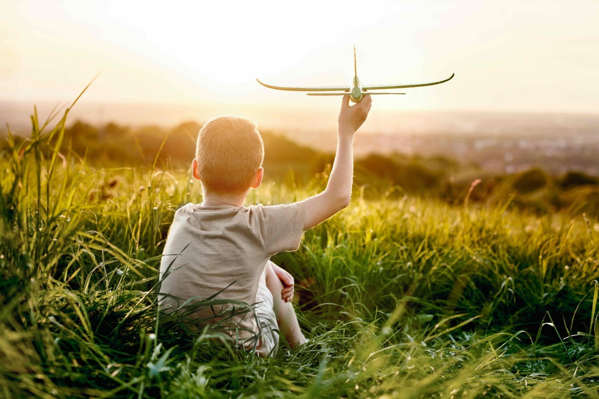 little boy sitting on the meadow with toy airplane 2022 06 10 06 47 39 utc