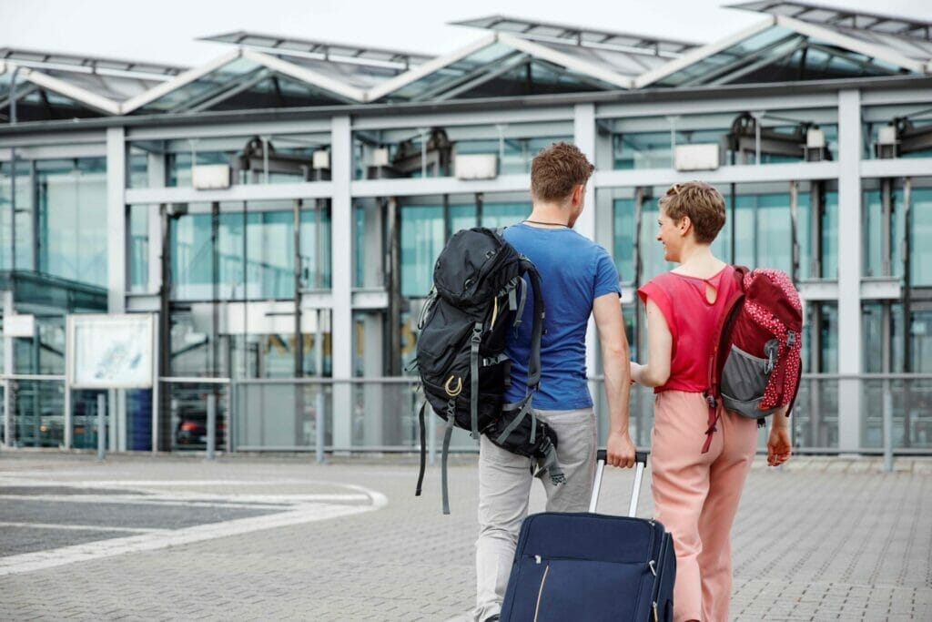 Rear view of couple walking outside airport