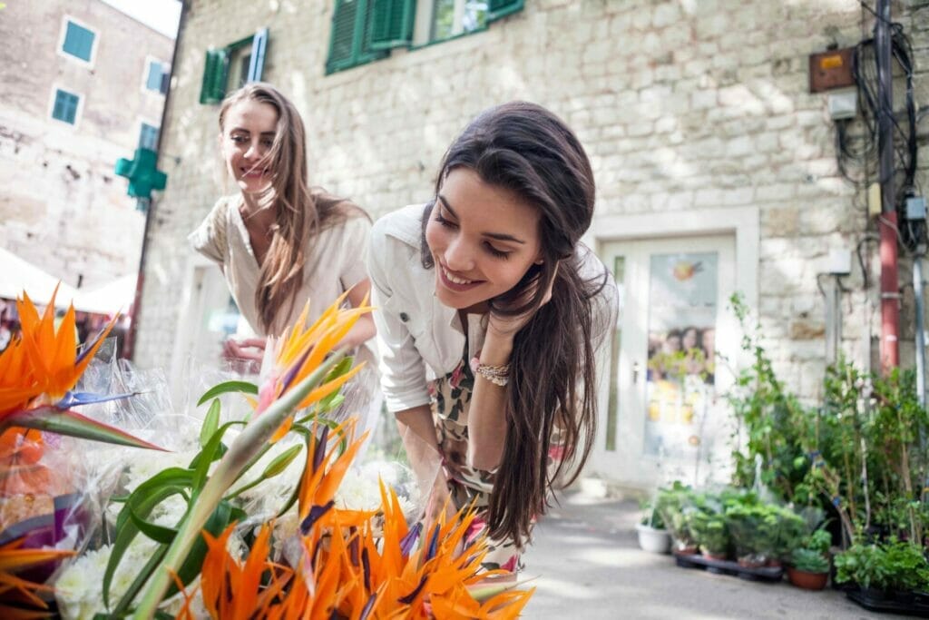 female tourists looking at flowers on market stall 2022 03 07 23 53 54 utc