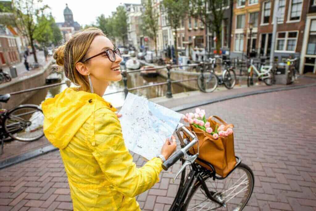 Traveling with map and bicycle standing on the bridge in Amsterdam city