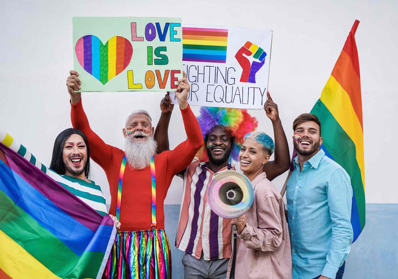 Happy multiracial people laughing with banner at gay pride parade